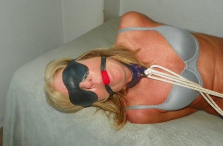 Blonde MILF sports a ball gag and blindfold while restrained in her pretties