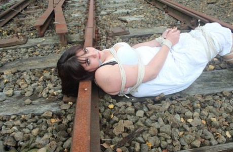 In a railway track slip, Brunette BBW is tied up and gagged.