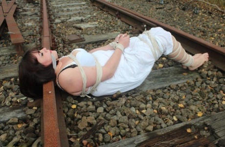 Slip on railway tracks and Brunette BBW is tied up and gagged.