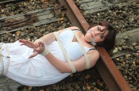 Brunette BBW is trapped and gagged in a railway track slip.