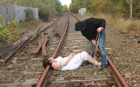 Stabbed in a railway track slip, Brunette BBW is left tied up and gagged.