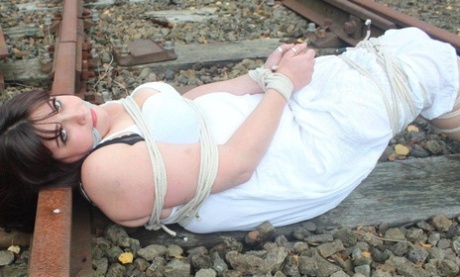 Ruined: Brunette BBW is tied up and gagged in one of the railway tracks slips.