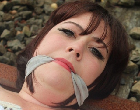 Trapped in a slip on railway tracks, Brunette BBW is left tied up and gagged.