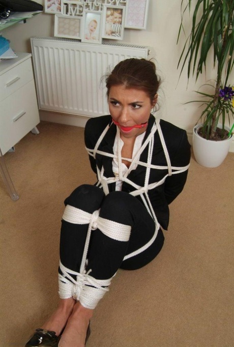 After being tied up with rope, a woman in her own clothing is held in place.