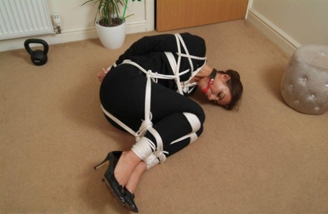 A fully clothed woman is held in place after being tied up with rope.