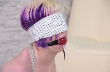 The color of her hair is dyed and a white girl with tied up in rope is blindfolded, leaving her gagged and gagging.