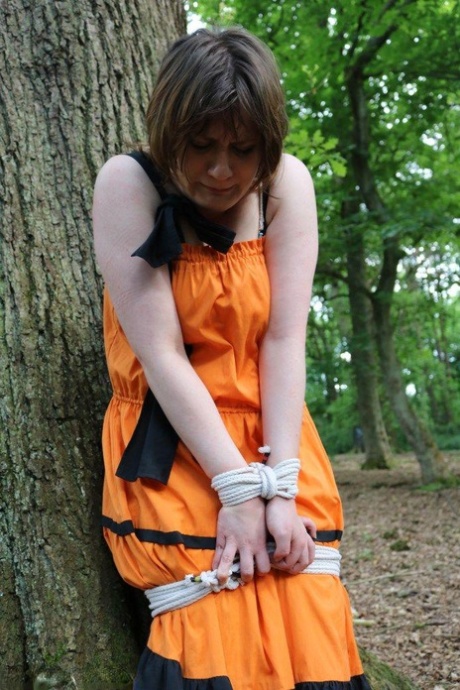 Gone: This fat woman is gagged and tied up to a tree in the woods with her clothes on.