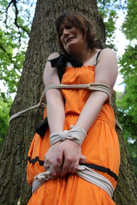 Her clothes are tied up on a tree in the woods, leaving an overweight woman gagged and naked.