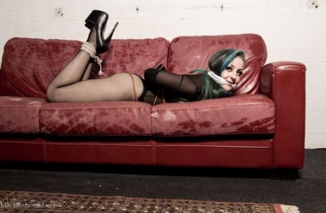 On a Chesterfield, an ordinary white girl with dyed hair finds herself gagged and hogtied.