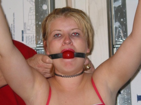 Before having her breasts revealed, the chubby blonde is given a ball gag.