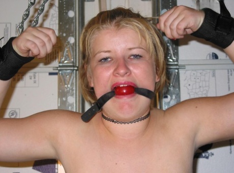 Chubby blonde is given a ball gag before her breasts are revealed.