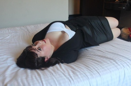 When the dark-haired lady is confined and gagged on a bed, she displays her breasts.