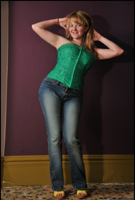 Sexy older woman Tasty Trixie flaunts her ample breasts in blue jeans and a bustier top.