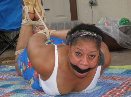 Mature Ebony Plumper Is Hogtied On A Comforter While Cleave Gagged