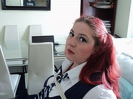 An obese schoolgirl with red hair is strapped down on a chair and has her cleaved off.