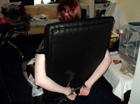 During a work setting, a heavy-set maid with red hair is ballgged and subjected to handcuffing due to being overweight.