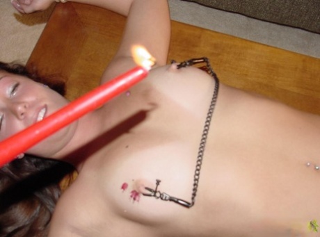 Tortured on the nipple: Naked no-aspian Chynna Lynn is held to her torso while tied to a table.