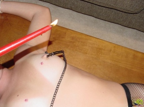 The nipple torture of Chynna Lynn, an unclothed woman, is being performed on her body while tied to a table.