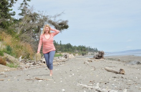 While at the beach, Tasty Trixie, a middle-aged woman, displays her flexible toe muscles and breast area.