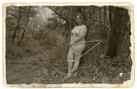 Overweight Female Is Tied To A Tree In The Woods While Naked And Blindfolded