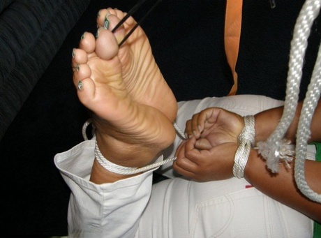 While being ball gagged, a heavy black woman is held up in her Santa bonnet.