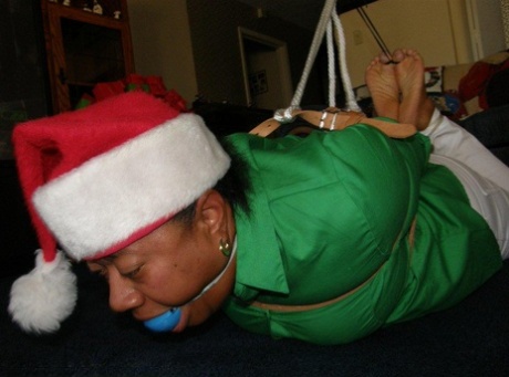 The Santa hat of an overweight black woman is being ball-stamped by her.