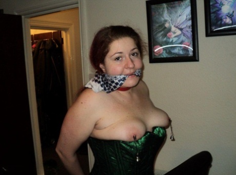 With her wrists handcuffed behind her back, Chubby redhead performs a cleave gag.