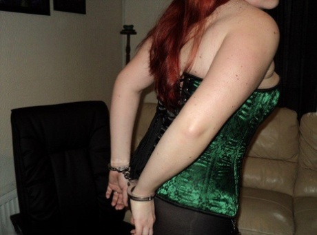 Chubby, the blonde, wears a cleave gag and has her wrists handcuffed behind her back.