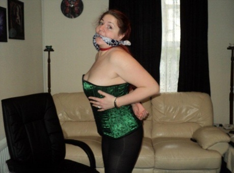 Chubby blonde with handcuffed wrists and a loose-fitting pose in the centre of her upper body as part of an elaborate cleave gag.