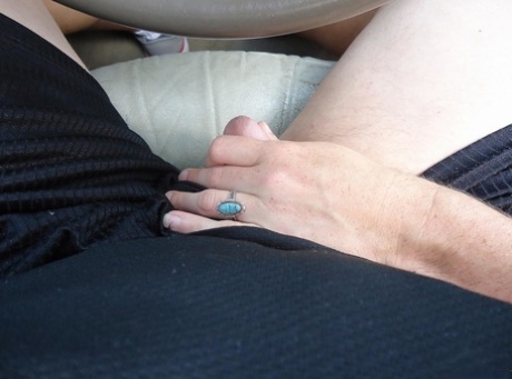 At the back of a car, Molly engages in fingering her pussy while playing with a female penis.
