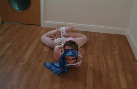 Blindfolded: Caucasian ballerina is tightly tied up while being gagged and held in the air.