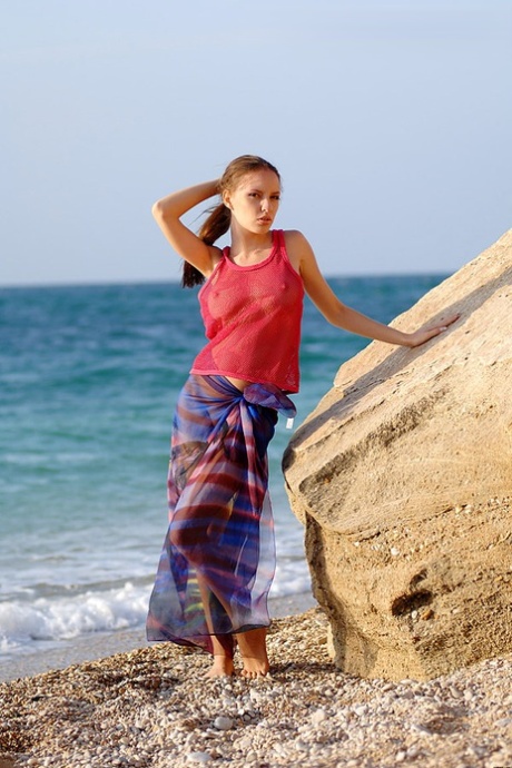 While at a pebbly beach, the lovely girl Aurita is seen in her wrap as she goes nude.