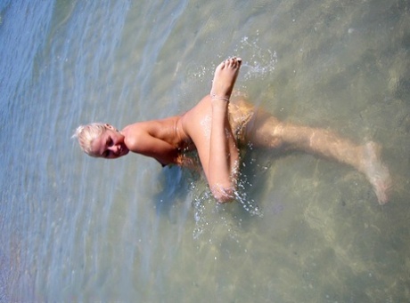 Naked, Adele - who is an amateur but still pretty blonde - jumps in the water.