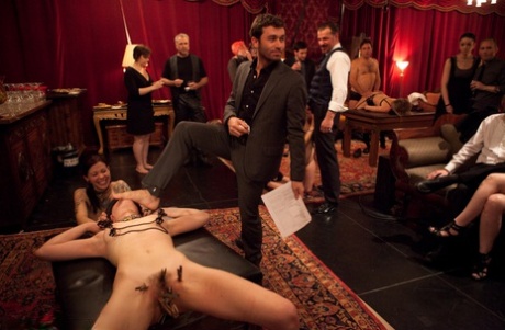 In this photo, female sex slaves are depicted having both heterosexual and lesbian sex at a party.
