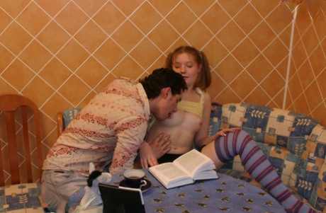 A redhead with a young appearance, Anna engages in sexual activity with her boyfriend while wearing over the knee socks.