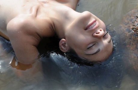 Underned, Tina plunges her body into shallow water close to the shore.