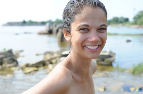 Naked amateur Tina immerses her body in shallow water near the shore