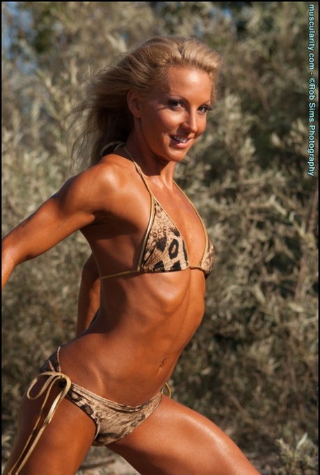 Blonde Bodybuilder Eva Dawes Flexes On Scrubby Ground In A Animal Print Bikini