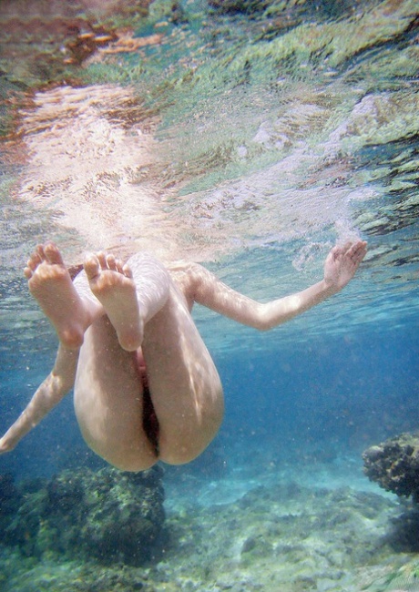 On the beach, Nao Yoshizaki from Japan dips into the water.