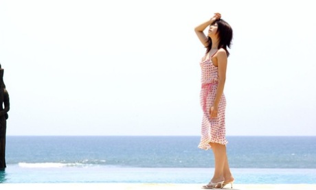 Saki Ninomiya, a young girl from Japan, exposes herself to the ocean while looking down.