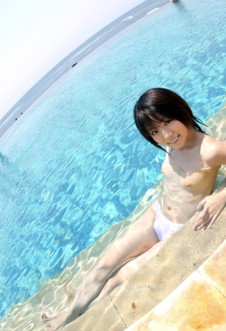 Smiling in front of the ocean, Saki Ninomiya is a young Japanese girl.