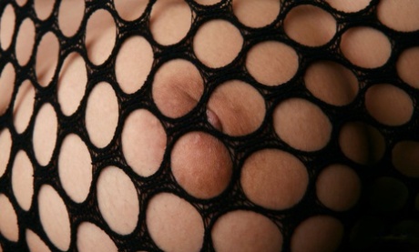 Japanese girl Seiko Yamaguchi squeezes her natural tits in the mesh bodystocking.