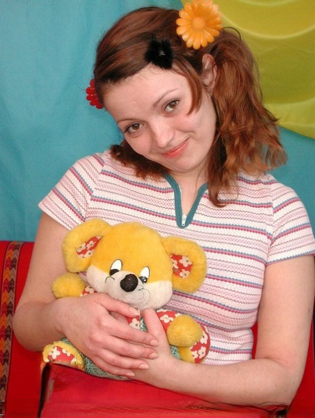 Prior to having sex with her boyfriend, the young redhead holds a Teddy Bear.