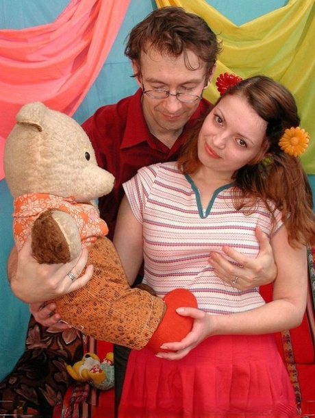 Young looking redhead holds a Teddy Bear before having sex with her boyfriend