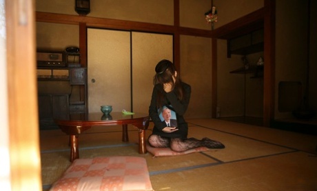 Shocked: Japanese wife Miho Sonoda fondles herself during the funeral service after her husband's death.