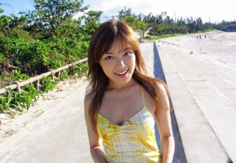 A charming Asian model enjoys posing on the beach and flaunting her firm tits.