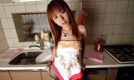 Miyu, a famous Japanese hottie with red hair, gets completely naked in the kitchen while watching TV.