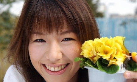 A charming Japanese student named Towa Aino displays her breasts in a cute manner by taking off her braces.