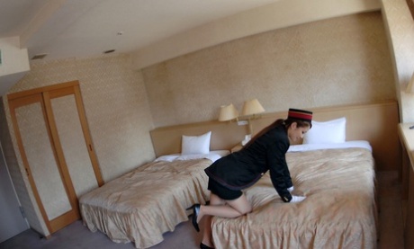 A Japanese hostess with red hair fondles her genitalia in a hotel room.