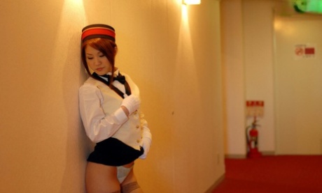 This image shows a Japanese hostess with red hair fondling her great belly in the middle of a hotel room.